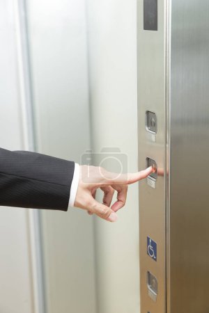 Téléchargez les photos : Main mâle appuyant sur le bouton ascenseur - en image libre de droit
