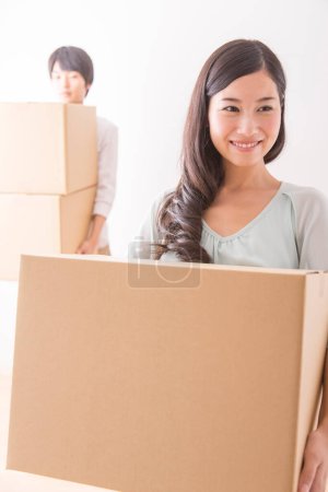 Téléchargez les photos : Jeune homme et femme asiatique avec des boîtes en carton déménageant dans un nouvel appartement - en image libre de droit