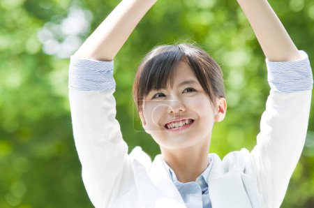 Téléchargez les photos : Heureux asiatique jeune femme d'affaires posant dans l 'parc - en image libre de droit