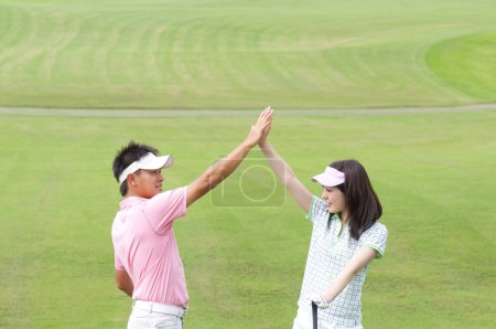 Photo for A man and woman giving each other a high five - Royalty Free Image