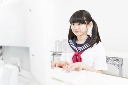 Photo for Portrait of beautiful young student in school uniform studying with computer - Royalty Free Image
