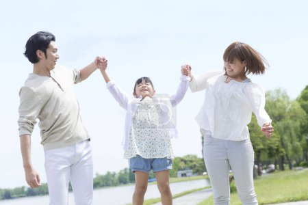 Foto de Feliz asiática familia madre, padre e hija pasando tiempo juntos en parque - Imagen libre de derechos