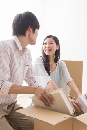 Photo for Young asian man and woman with cardboard boxes moving into new apartment - Royalty Free Image