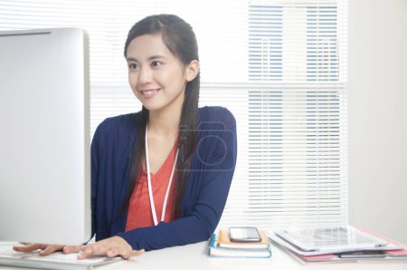 Téléchargez les photos : Jeune femme travaillant à l'ordinateur au bureau - en image libre de droit