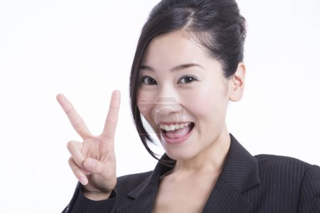 Photo for Portrait of expressive young japanese businesswoman showing v sign isolated on white - Royalty Free Image