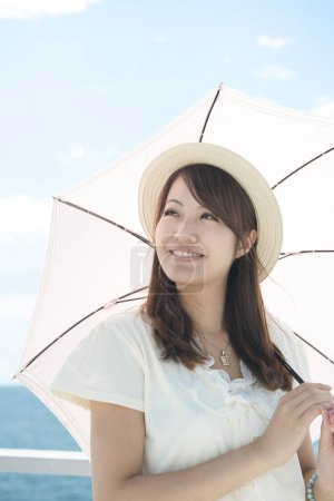 Photo for Woman with umbrella and sea background - Royalty Free Image