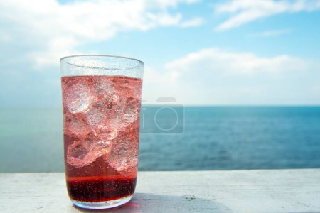 Foto de Un vaso de agua con hielo y una vista del océano - Imagen libre de derechos