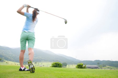 Téléchargez les photos : Jeune golfeuse jouant au golf - en image libre de droit