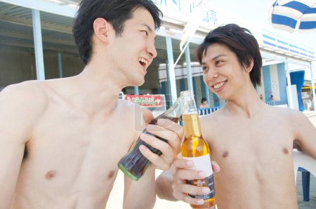 Foto de Dos hombres bebiendo cerveza y soda en la piscina - Imagen libre de derechos
