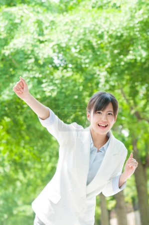 Foto de Retrato al aire libre de la alegre mujer japonesa caminando en el verde parque de verano - Imagen libre de derechos