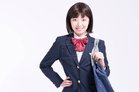 Téléchargez les photos : Portrait studio d'écolière japonaise souriante avec sac - en image libre de droit