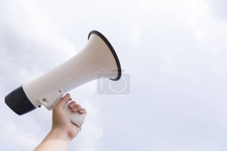 Photo for Megaphone in hand on blue background. - Royalty Free Image