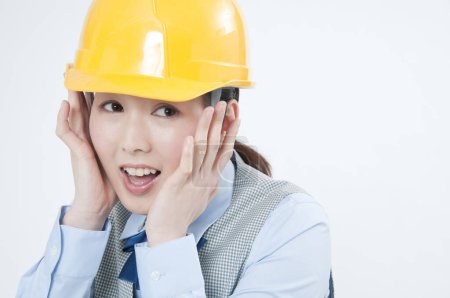 scared asian female construction worker in  helmet
