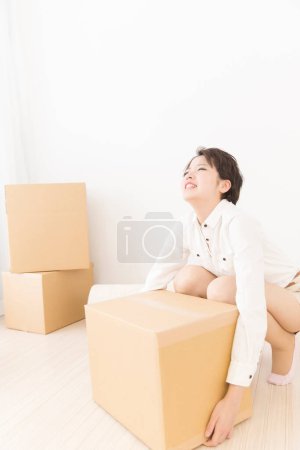 Téléchargez les photos : Belle femme asiatique avec des boîtes en carton à la maison - en image libre de droit