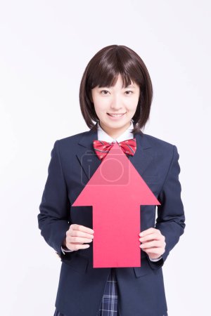 Photo for Studio portrait of smiling Japanese schoolgirl with red arrow - Royalty Free Image