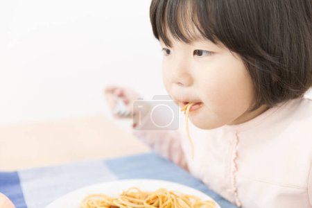 Foto de Asiático niña comer spaghetti - Imagen libre de derechos