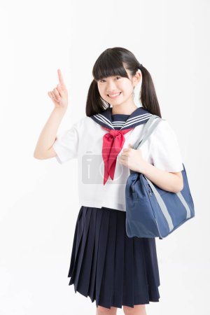 Photo for Portrait of beautiful young student in school uniform pointing on white background - Royalty Free Image