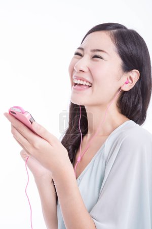 Téléchargez les photos : Jeune femme avec téléphone portable écoutant de la musique - en image libre de droit