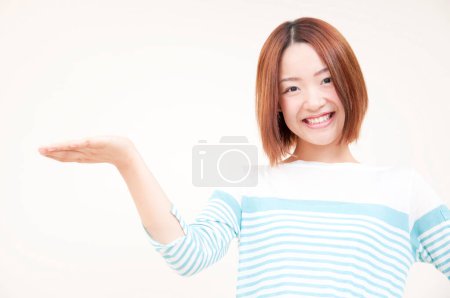 Téléchargez les photos : Portrait de belle jeune femme japonaise sur fond beige - en image libre de droit