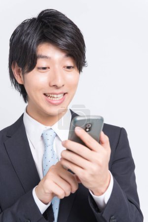 Téléchargez les photos : Homme d'affaires utilisant un téléphone portable, plan studio - en image libre de droit