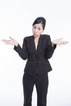 Foto de Retrato de la joven empresaria japonesa expresiva triturando hombros aislados en blanco - Imagen libre de derechos