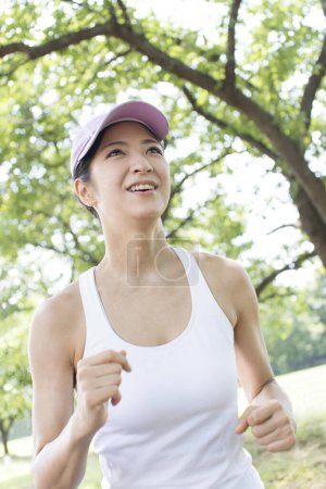 Téléchargez les photos : Femme japonaise sportive faisant du jogging dans un parc d'été - en image libre de droit