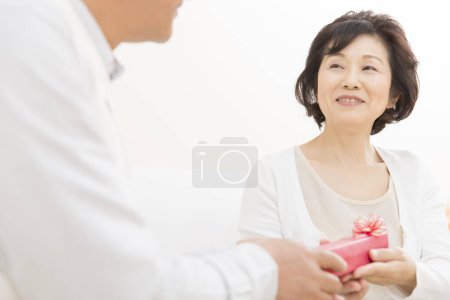 Téléchargez les photos : Senior asiatique femme et homme tenant cadeau - en image libre de droit