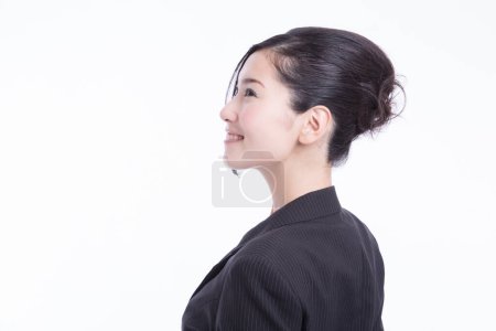 Téléchargez les photos : Jeune femme d'affaires japonaise en costume décontracté debout sur fond de studio blanc - en image libre de droit
