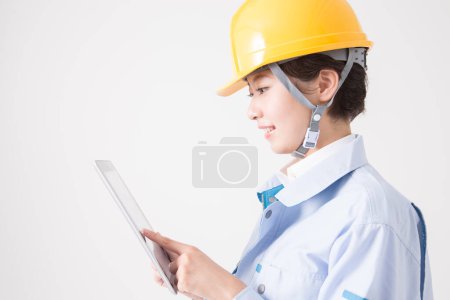 Foto de Joven ingeniera en casco amarillo y tableta pc - Imagen libre de derechos