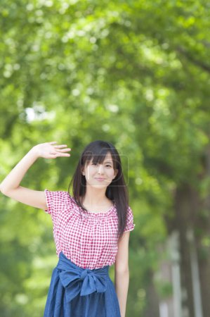 Photo for Young woman waving hand  in the summer park - Royalty Free Image
