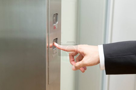 Téléchargez les photos : Main mâle appuyant sur le bouton ascenseur - en image libre de droit