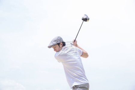 Téléchargez les photos : Asiatique l'homme dans un blanc chemise et gris pantalon jouer golf - en image libre de droit