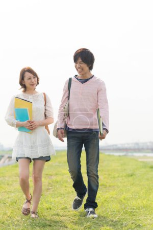Téléchargez les photos : Couple de jeunes étudiants japonais heureux passer du temps ensemble sur la nature - en image libre de droit