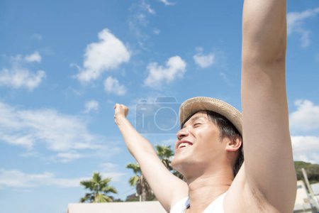 Photo for Portrait of young asian man with arms outstretched outdoors - Royalty Free Image