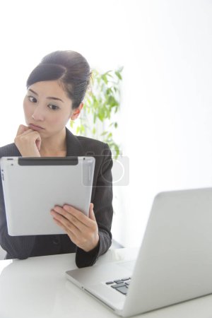 Photo for Young woman working with a laptop and tablet - Royalty Free Image