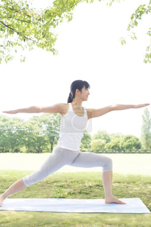 Téléchargez les photos : Belle japonais femme faire yoga dans parc - en image libre de droit