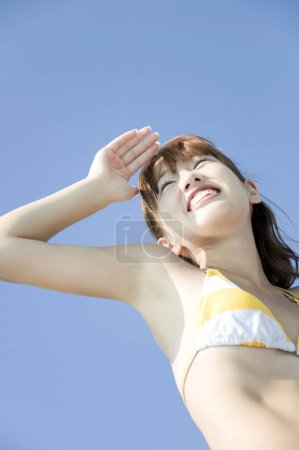 Photo for Young Japanese woman in colorful swimsuit having fun at pool, vacation concept - Royalty Free Image