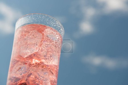 Foto de Un vaso de soda con hielo sobre fondo azul del cielo - Imagen libre de derechos