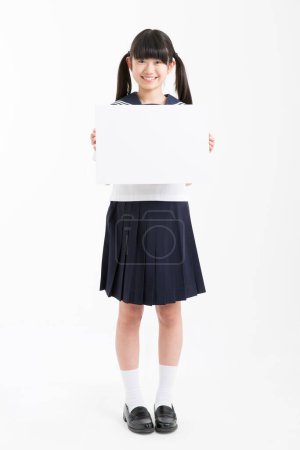 Photo for Portrait of beautiful young student in school uniform holding white blank board - Royalty Free Image
