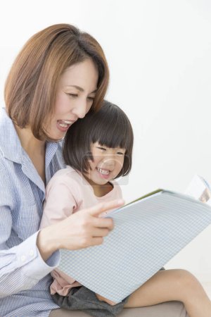 Photo for Asian mother and daughter reading book - Royalty Free Image