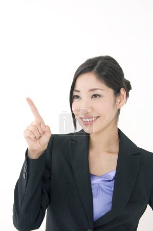 Téléchargez les photos : Jeune asiatique femme d'affaires avec doigt vers le haut sur fond blanc - en image libre de droit