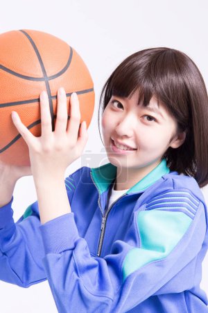 Téléchargez les photos : Portrait studio de jeune fille asiatique en vêtements de sport avec ballon de basket - en image libre de droit