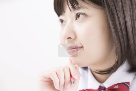Téléchargez les photos : Portrait de belle jeune écolière japonaise en uniforme - en image libre de droit