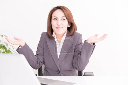 portrait of mature japanese businesswoman at office shredding shoulders