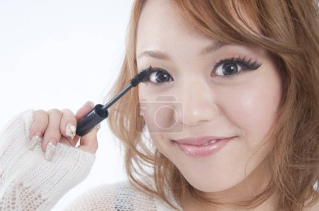 Photo for Young woman applying mascara - Royalty Free Image