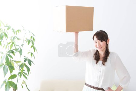 Téléchargez les photos : Asiatique femme tenant boîte en carton - en image libre de droit