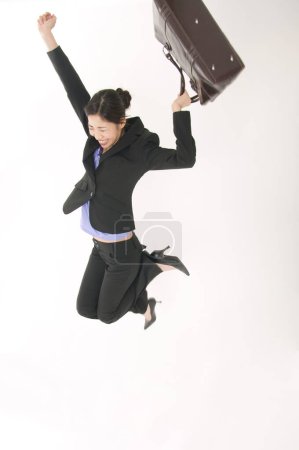 Photo for Businesswoman jumping in studio on isolated background - Royalty Free Image