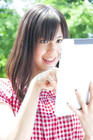 Photo for Beautiful Japanese young woman using tablet. close up view - Royalty Free Image