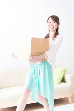 Foto de Mujer asiática con caja de cartón pesada - Imagen libre de derechos