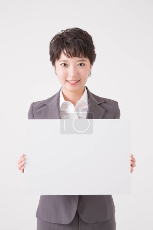 Téléchargez les photos : Jeune femme d'affaires asiatique en costume d'affaires avec planche vide pour le texte - en image libre de droit
